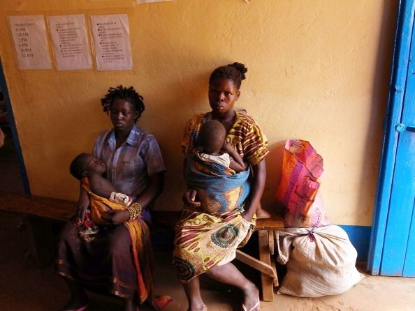 Una madre y sus hijos en Sudán esperan del tratamiento para la malaria.
