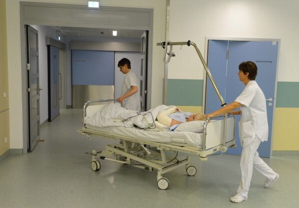 Enfermeras en movimiento a un paciente y la cama a través de un hospital. Un estudio de las enfermeras encontraron una asociación entre trabajar muchas horas y tener dificultad para quedar embarazada.