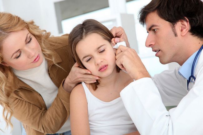 Doctor que mira la pequeña niña infección del oído
