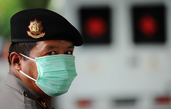 Un oficial de policía de Indonesia lleva una máscara mientras se guarda el procedimiento de identificación de AirAsia QZ8501 vuelo desastre
