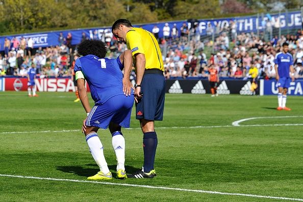 Un entrenador comprueba en un jugador de fútbol joven. La AMA tiene una nueva política para los jóvenes adultos con sospecha de una conmoción cerebral.