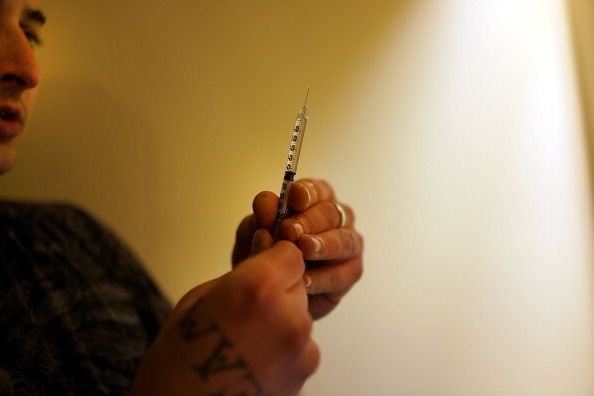 Un usuario de drogas por vía intravenosa se prepara para disparar hacia arriba. Un usuario de drogas por vía intravenosa se prepara para disparar hacia arriba.