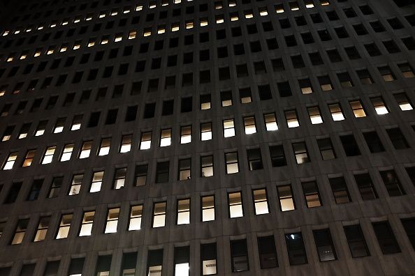 Las luces están encendidas temprano en la mañana en un gran edificio de oficinas, pero trabajando más de 55 horas a la semana pueden aumentar el riesgo de accidente cerebrovascular.
