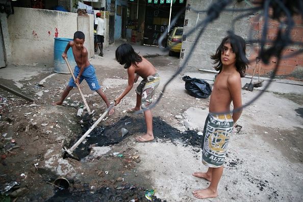 Chidren intentar destapar una alcantarilla en Río de Janeiro. Alcantarillado abierto como éste podría extenderse tifoidea.