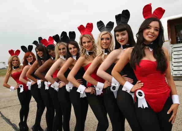 Conejitas de Playboy plantean a la espera de fundador de Playboy Hugh Hefner para llegar al aeropuerto de Stansted.