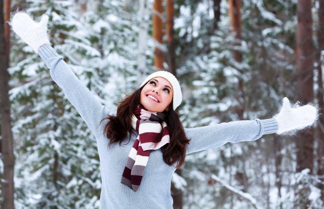 Mujer feliz en un bosque de invierno